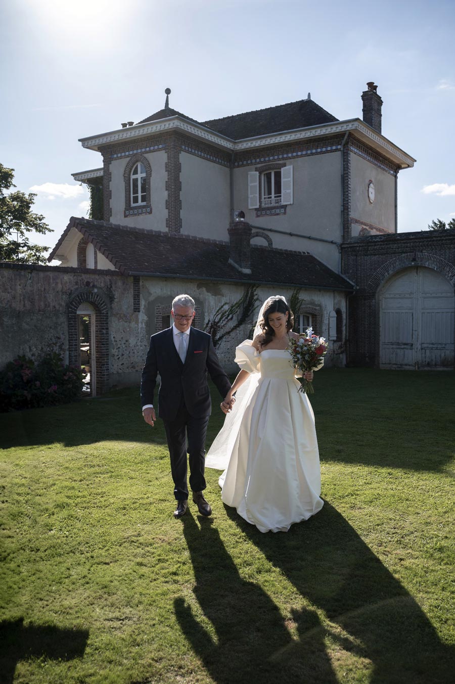 A bride and her father who are walking to go to the ceremony